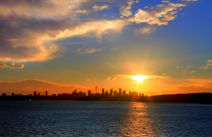 Sun setting over Sydney Harbour with City silhouette